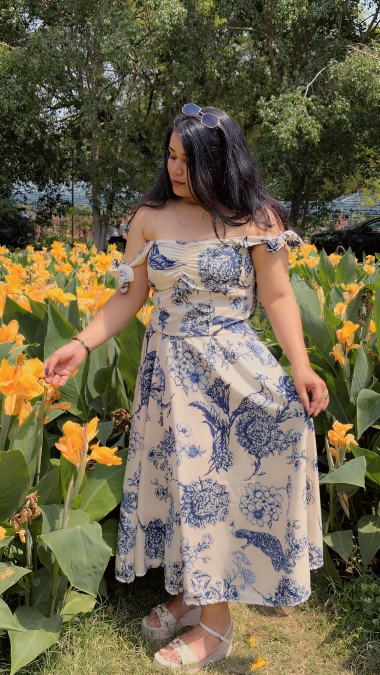 Woman in a floral dress standing among yellow flowers
