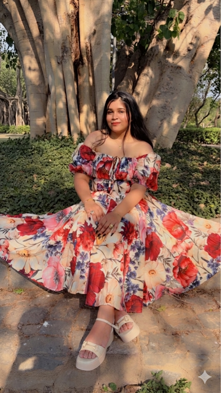 Woman in a floral dress sitting under a large tree